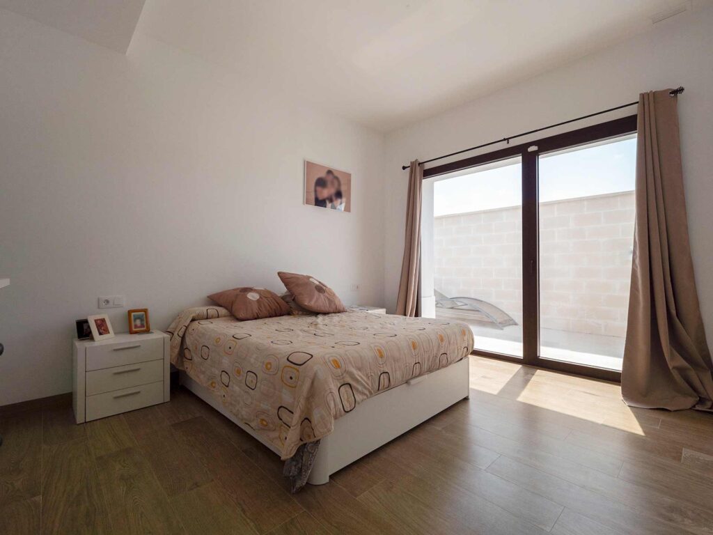 Dormitorio con SATE y suelo radiante Habitación con luz exterior en vivienda actual minimalista